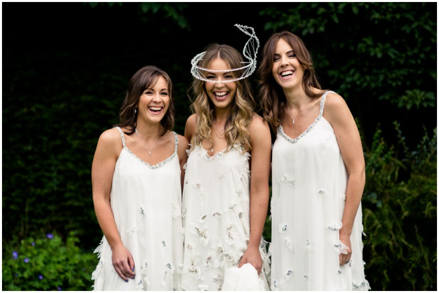 Bride and Bridesmaids laugh in beautiful flowing designer dresses 