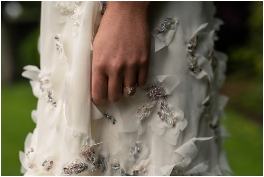 Details of designer wedding dress hand beaded with thousands of Swarovski crystals with beautiful engagement ring 