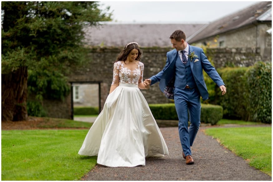 Bride and Groom walk hand in hand through the gardens of Tankardstown 