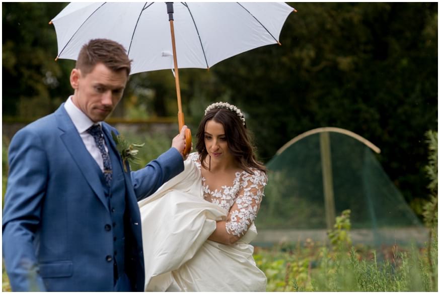 Bride and groom under a white umbrella 