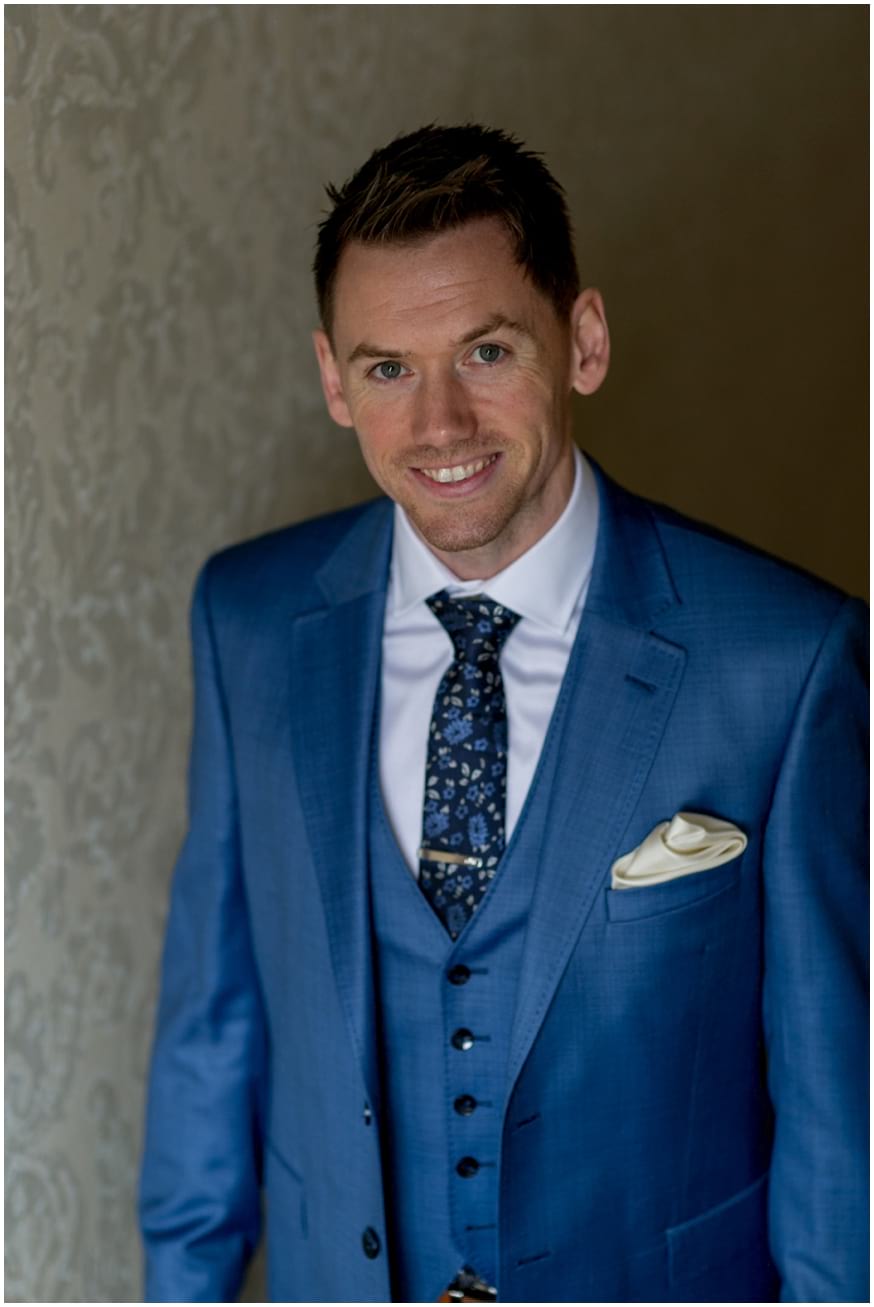 Groom in dark blue suit and navy floral tie