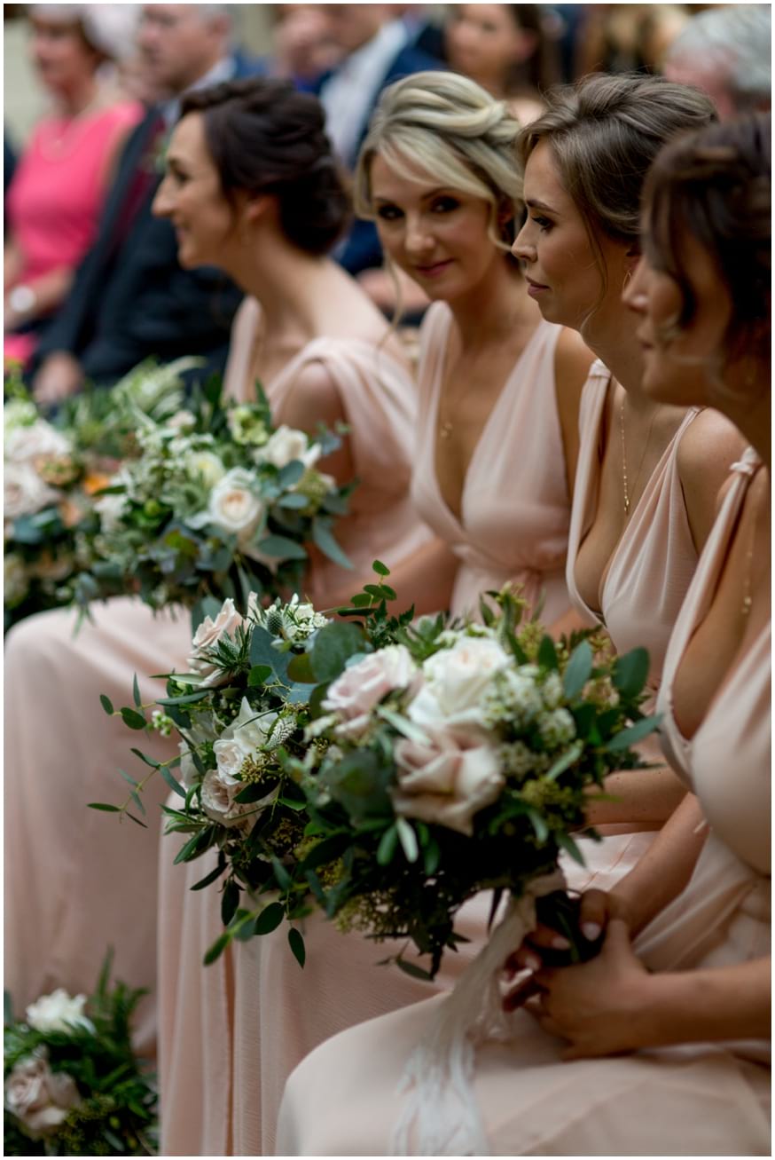 Bridesmaids light summery peach dresses and pastel bouquets 