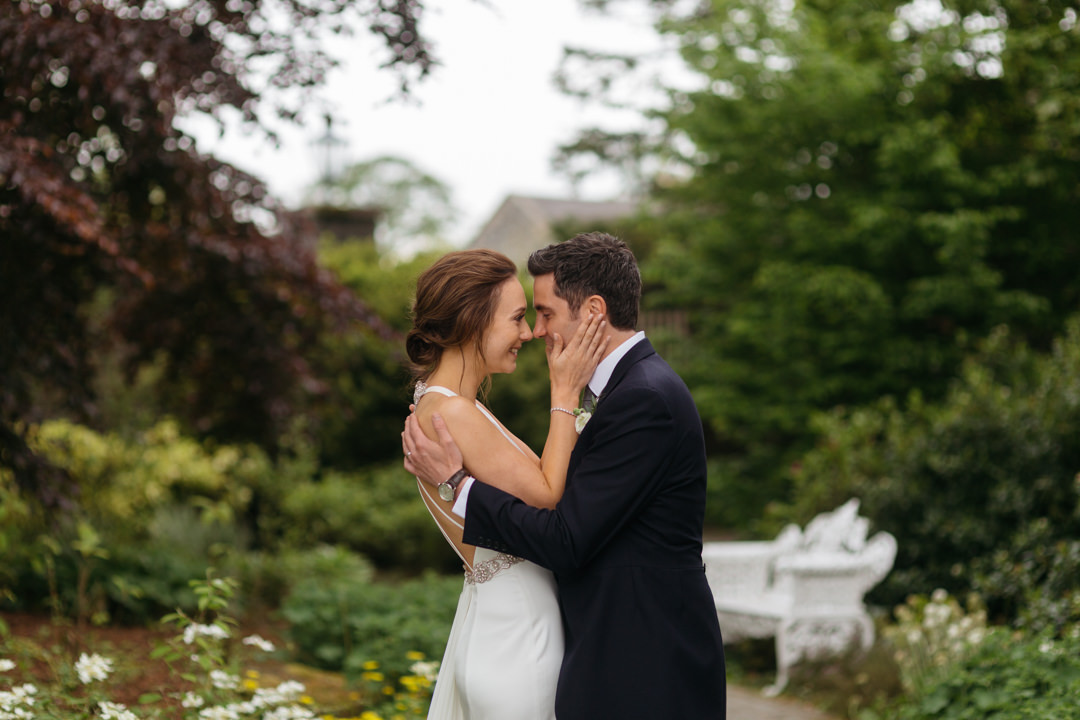 Bride and groom share an emotional moment in the garden at Ballymagarvey Village