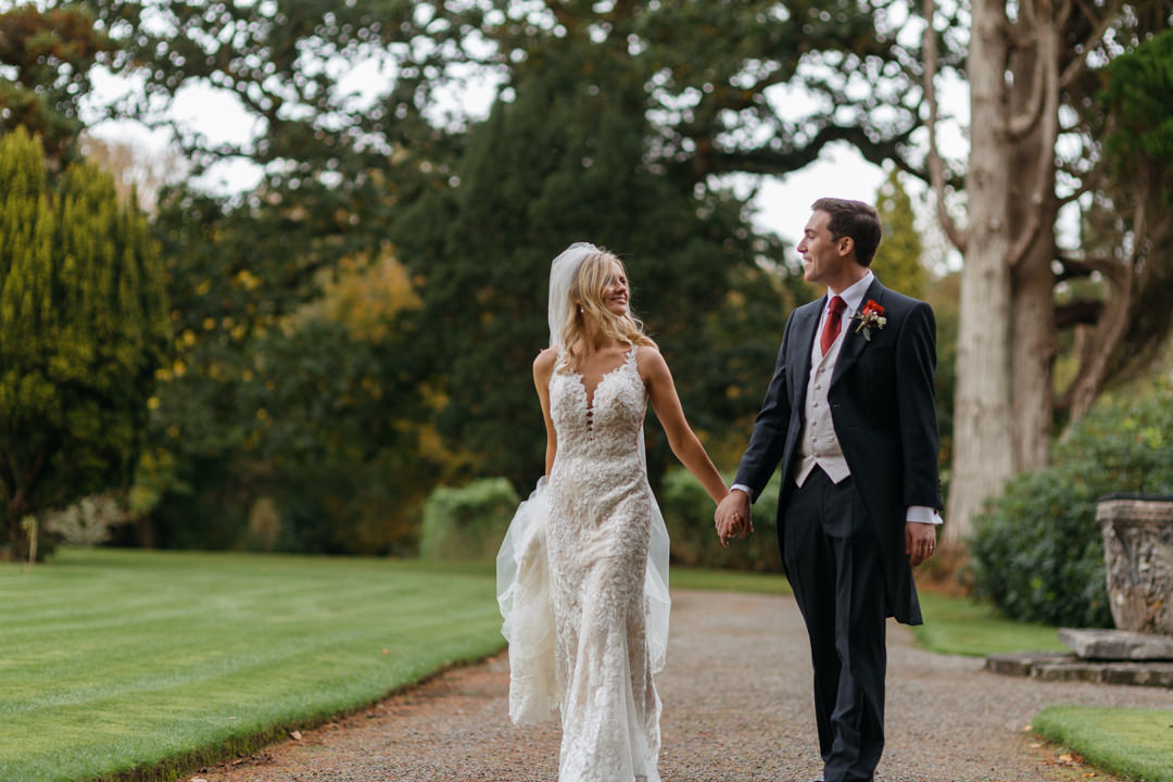 Newlyweds walk hand in hand through the gardens at Markree Castle 